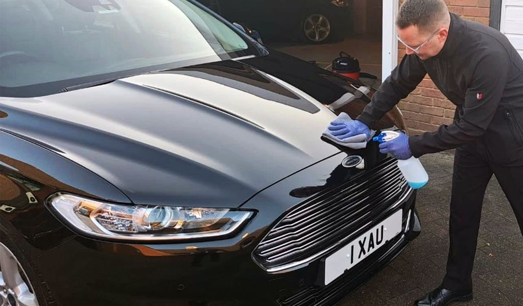 One of the Farthing Funeral Service team cleaning their hearse.